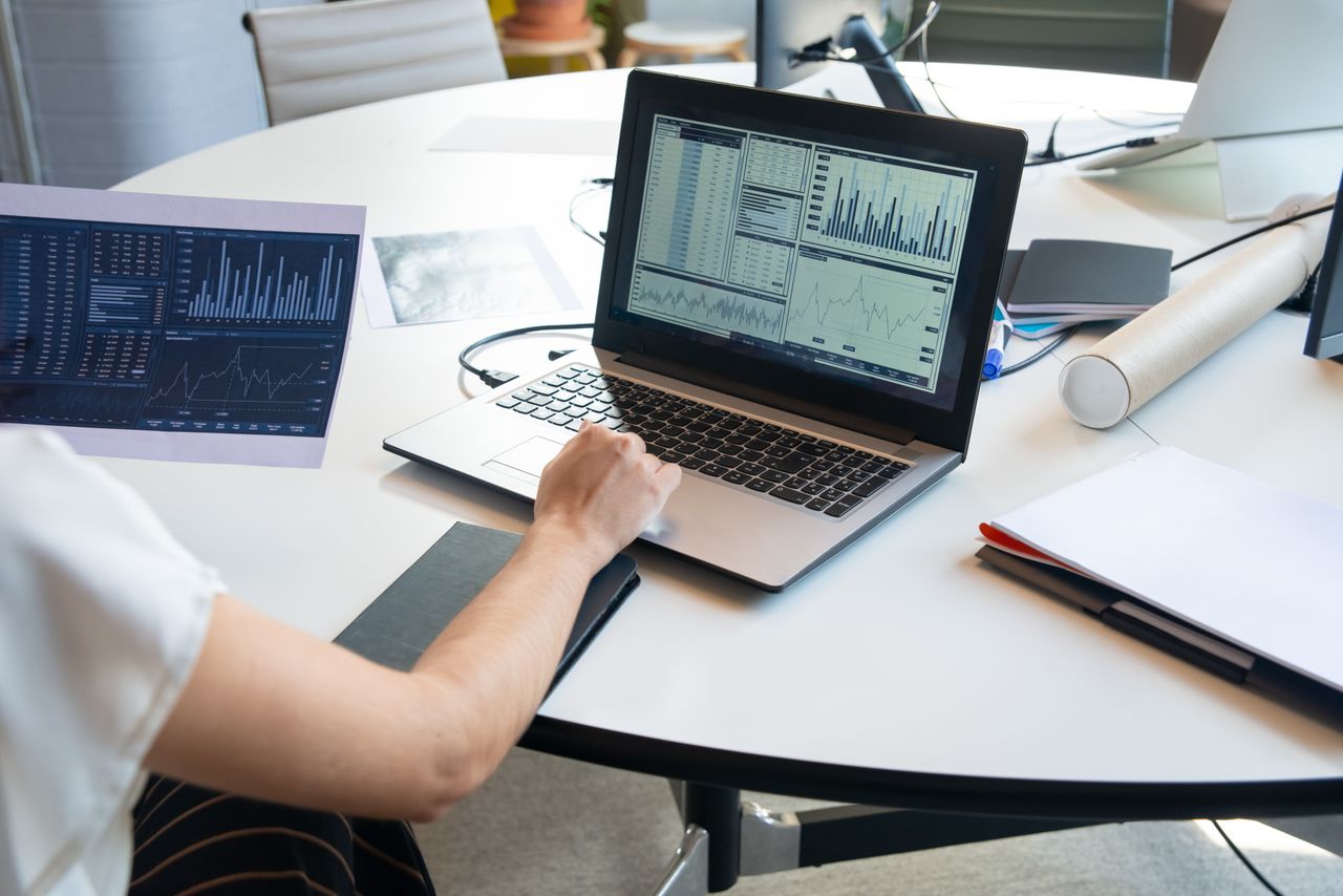 heros-img Business person evaluating financial charts on a laptop in a modern office setting.