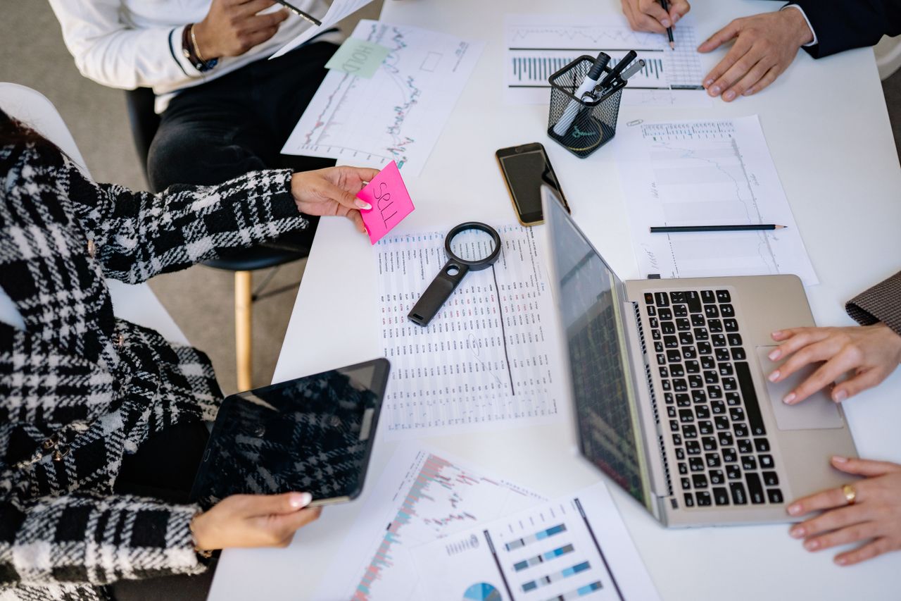 about-us-02 Business professionals collaborating on financial data analysis in a modern office setting.